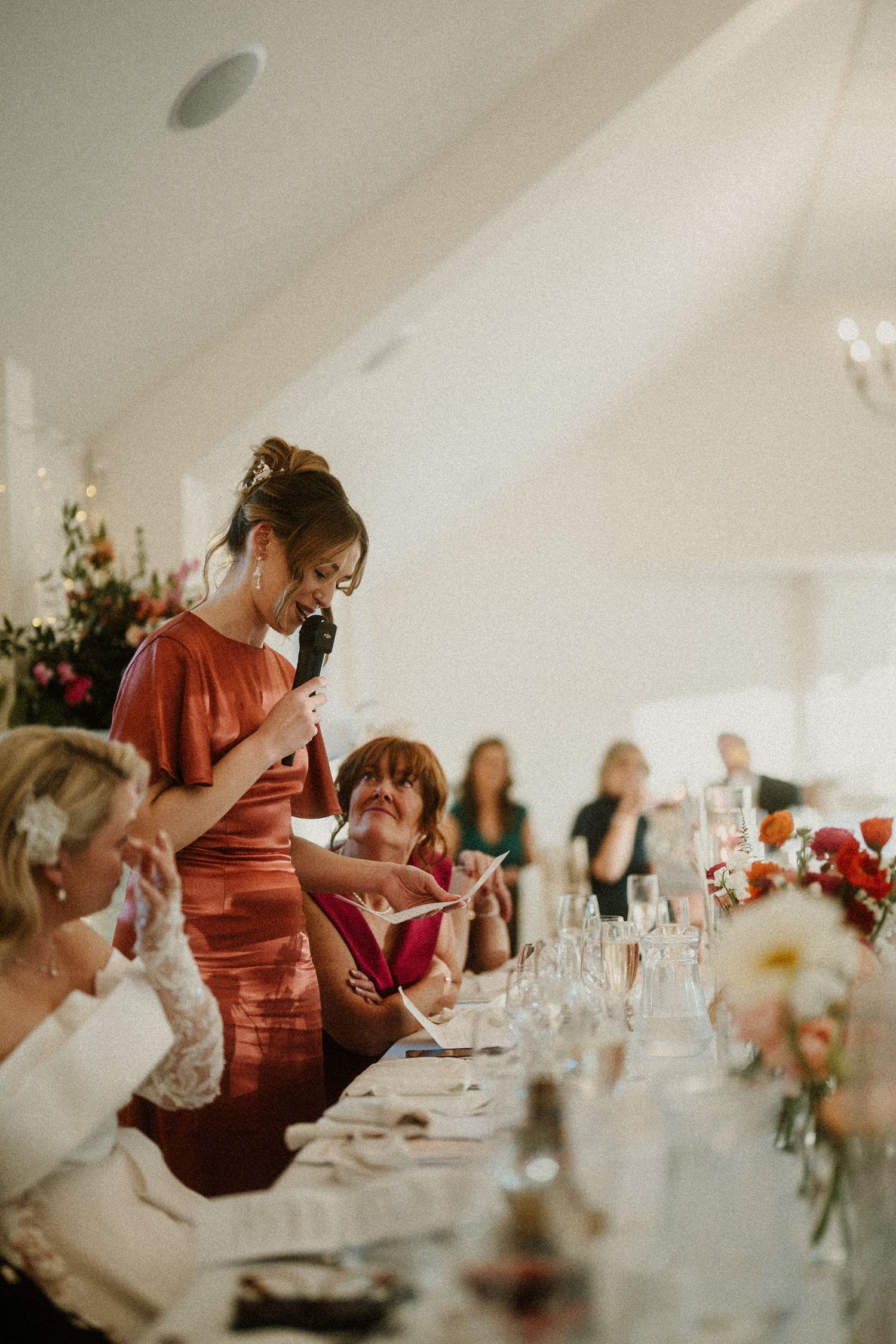 Wedding guests seated at long tables during an elegant indoor reception.