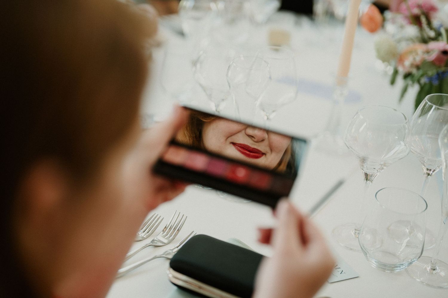 Close-up of table settings with wine glasses and place cards at wedding reception.