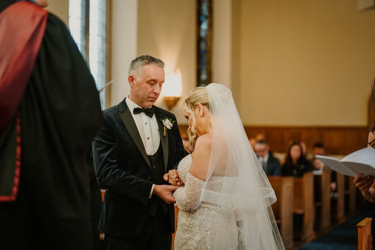 A couple shares an intimate moment during their wedding ceremony in a church.