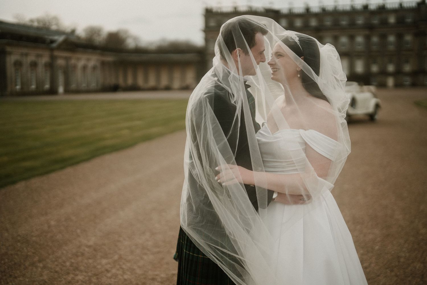 Romantic wedding moment captured against the backdrop of a grand Scottish estate.