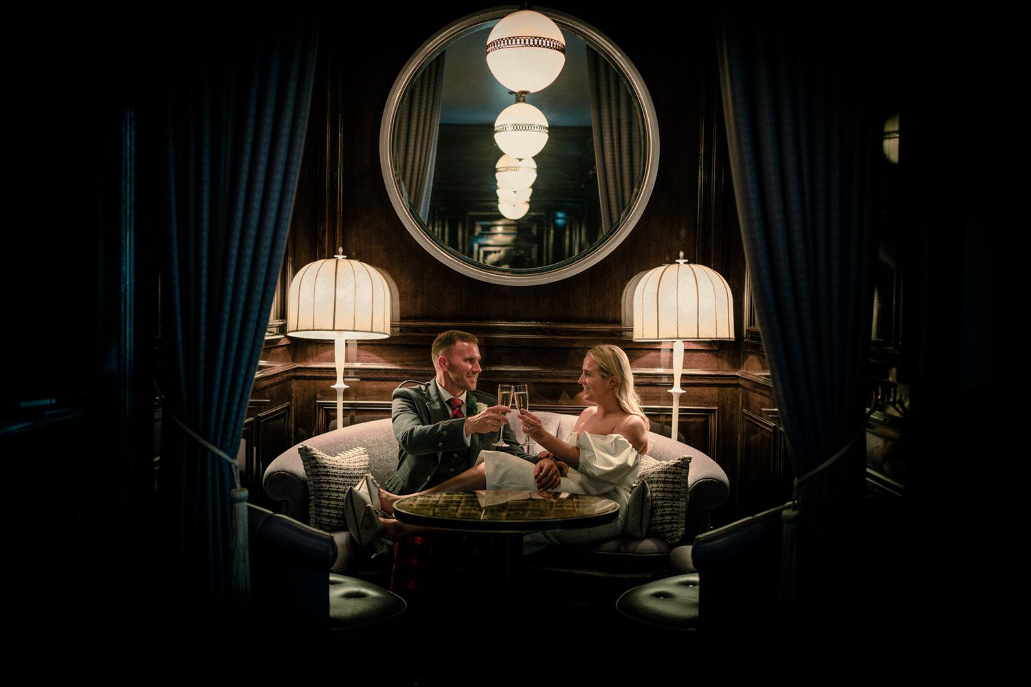 Dark and moody wedding reception scene with dramatic lighting and reflective surfaces.