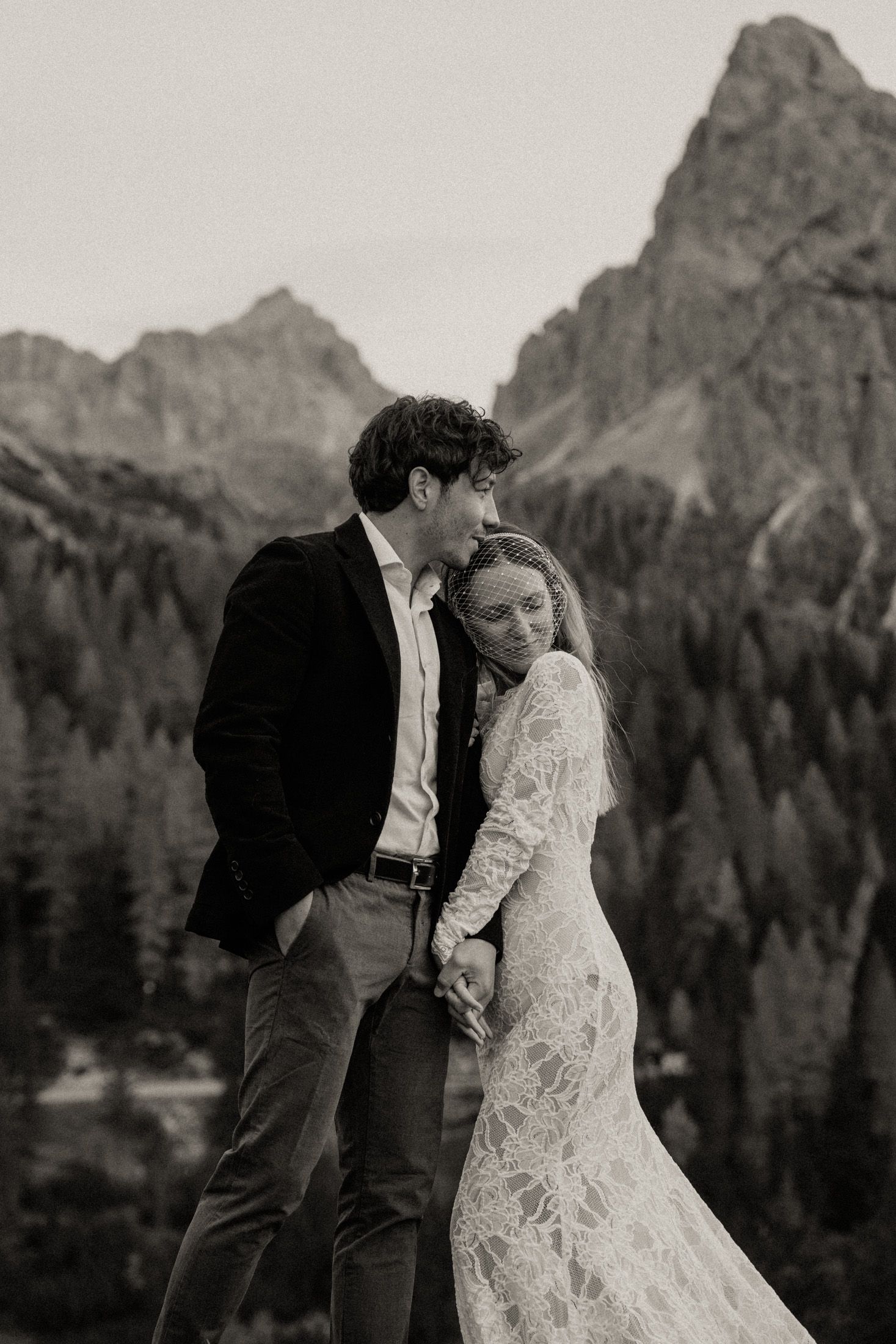 Intimate wedding portrait against majestic mountain backdrop in black and white.