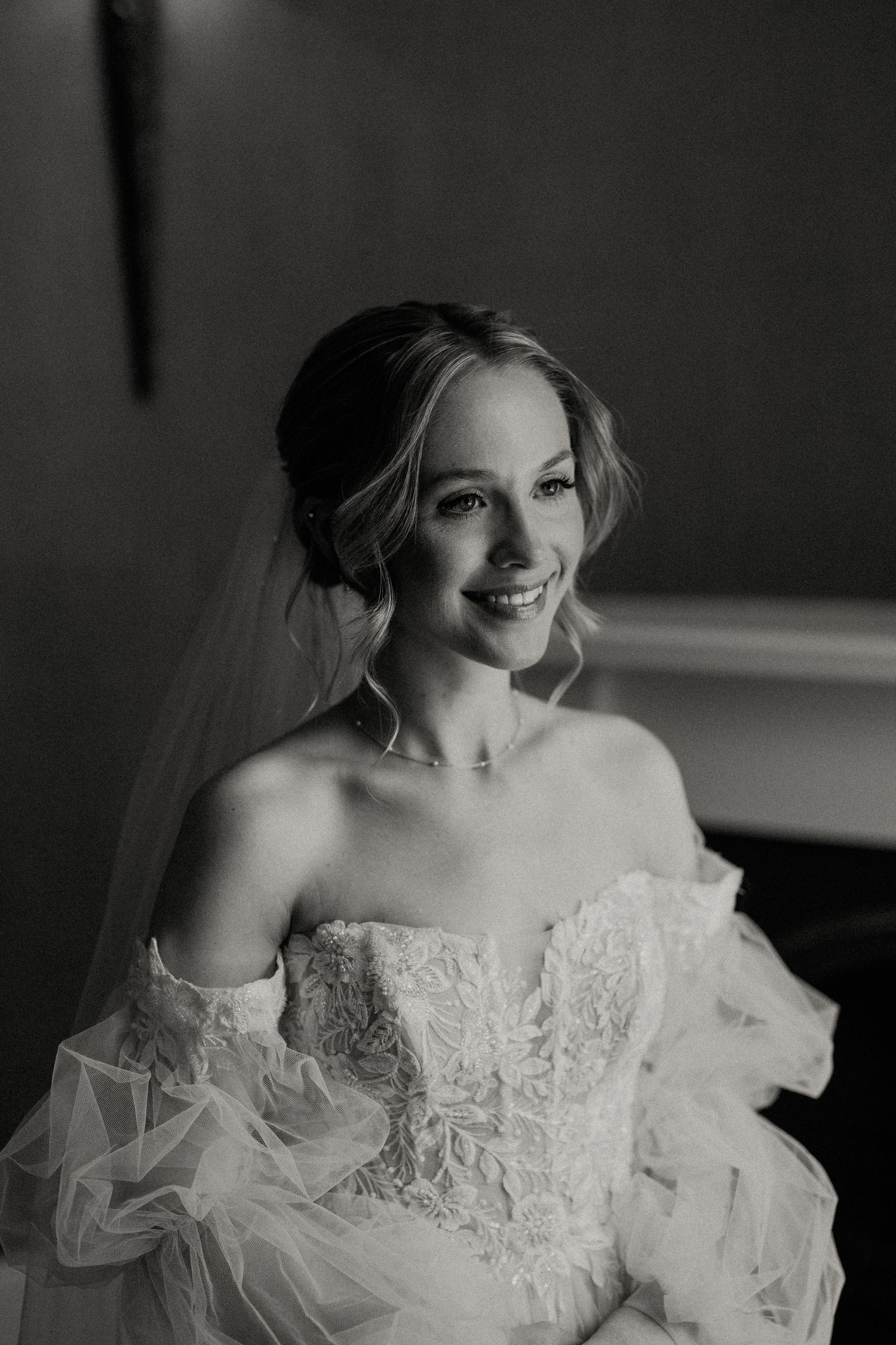 Elegant off-shoulder wedding dress with intricate lace detailing and sheer sleeves.