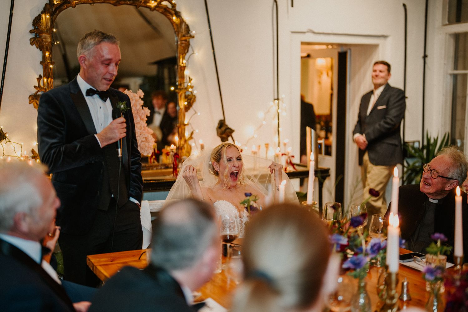 Wedding reception features vintage gold mirrors and candlelight creating a warm, romantic atmosphere.