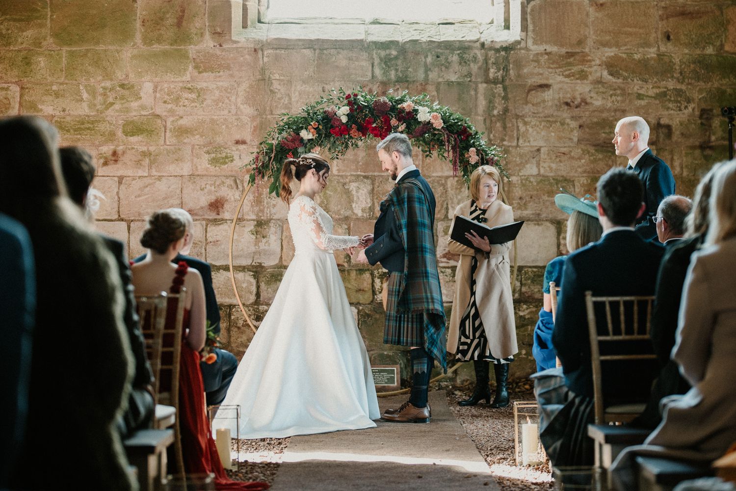 Stone church wedding venue with white window and romantic floral decorations.