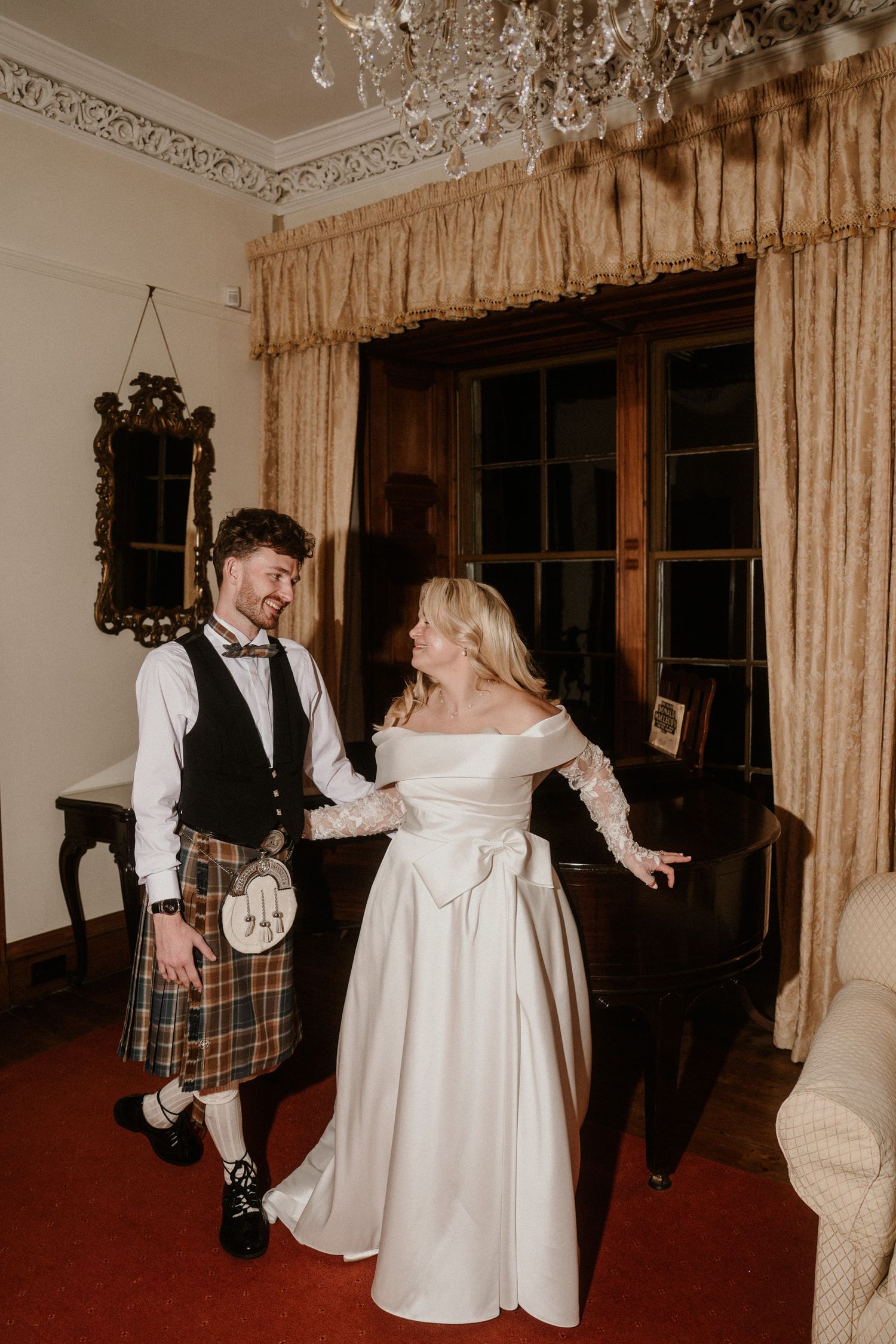 Joyful dance sequence in an elegant room with vintage curtains and red carpet.
