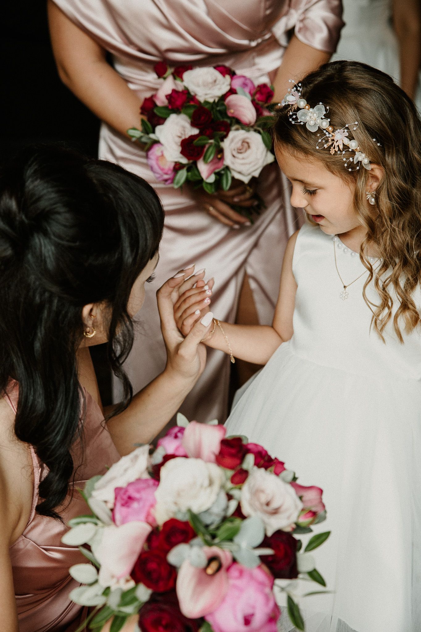 Wedding party gathering with pink and burgundy bouquets and blush bridesmaid dresses.