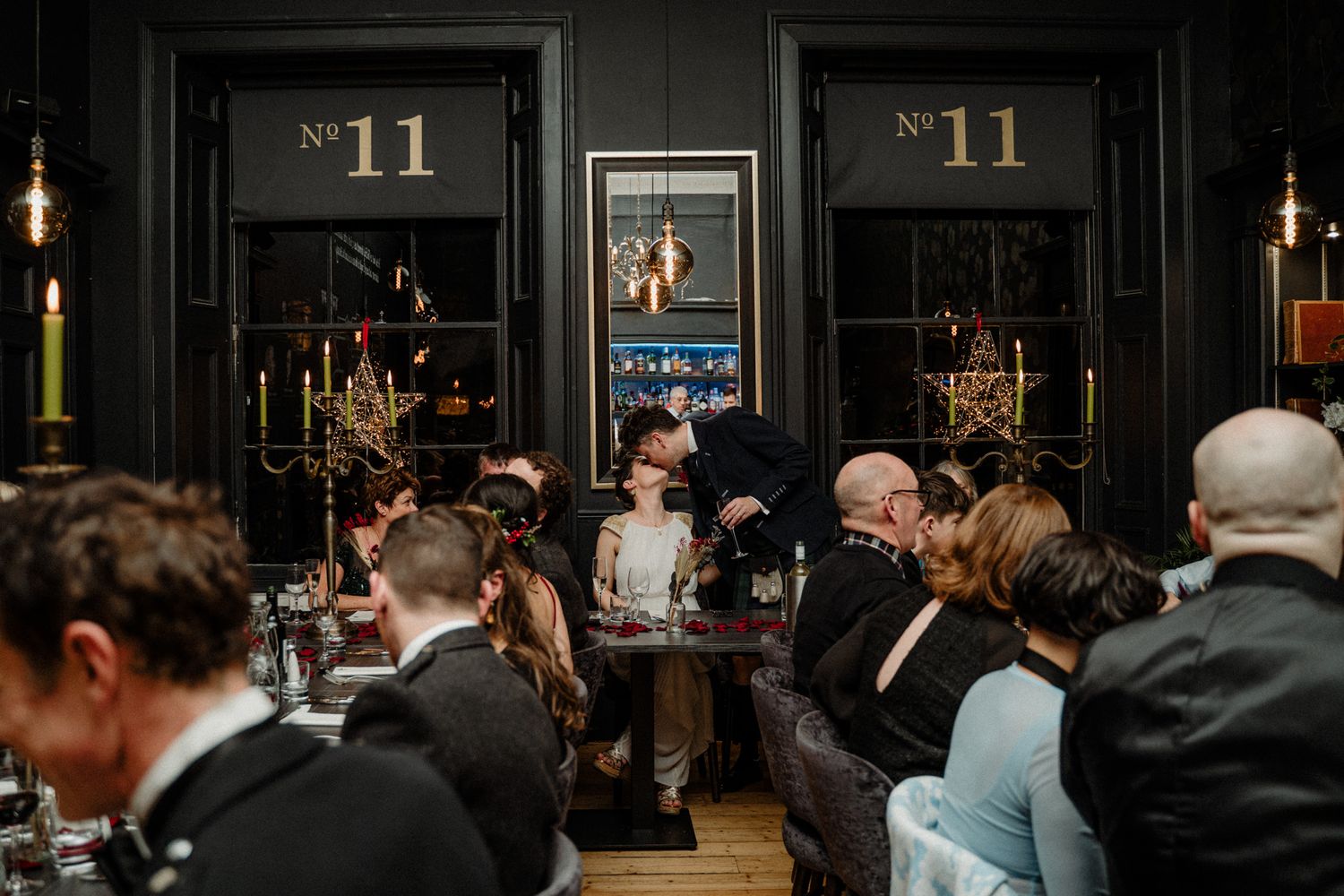 Dark reception venue with hanging lights and number 11 signage on the walls.