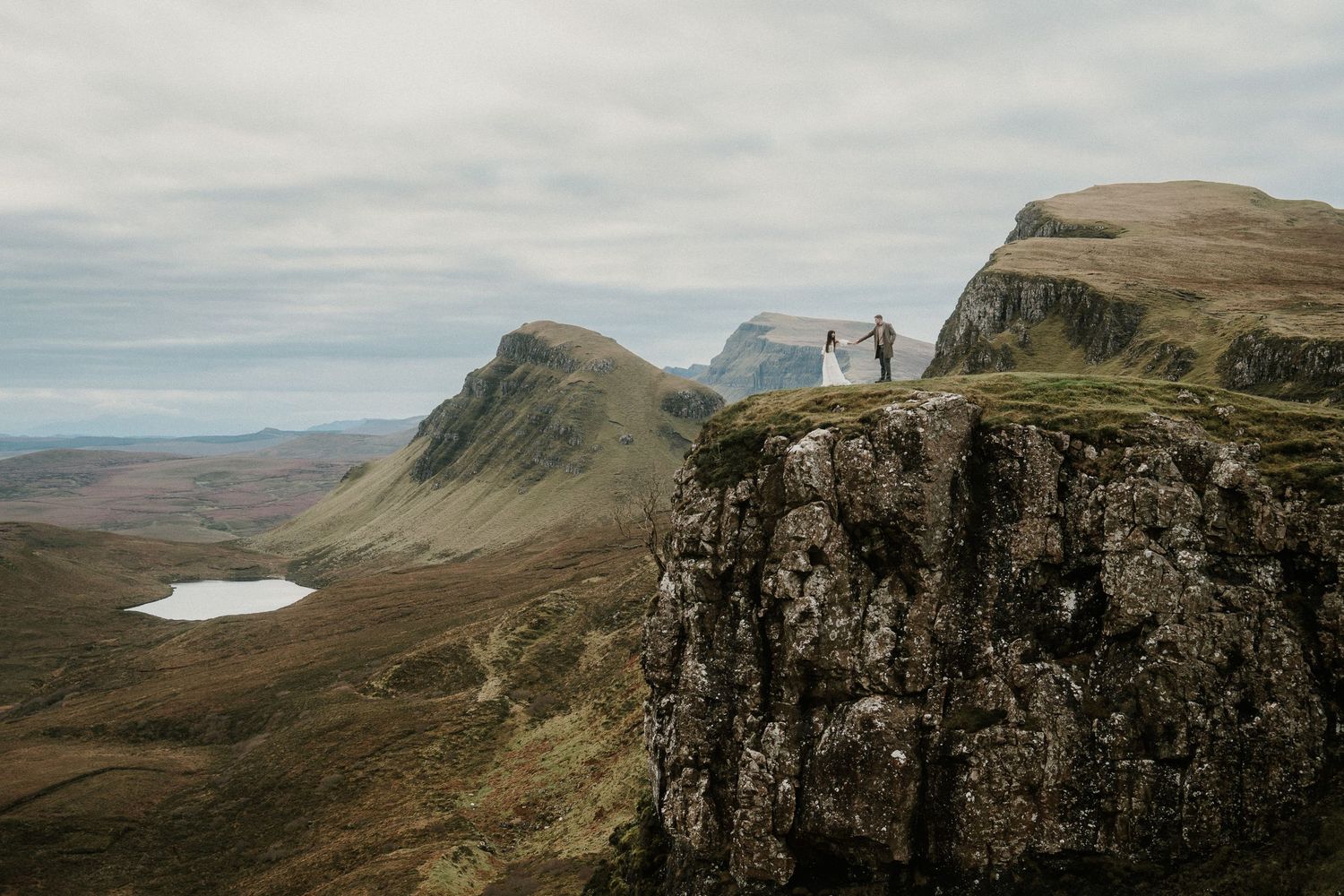 Panoramic view of rugged Scottish highland cliffs and valleys stretching to the horizon.
