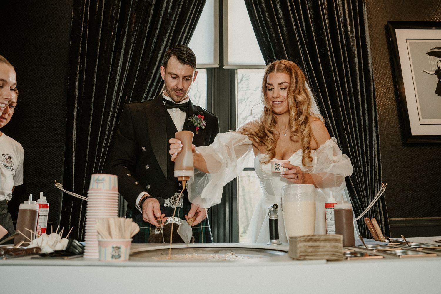 Wedding couple and guests mix drinks at an elegant bar during reception celebration.