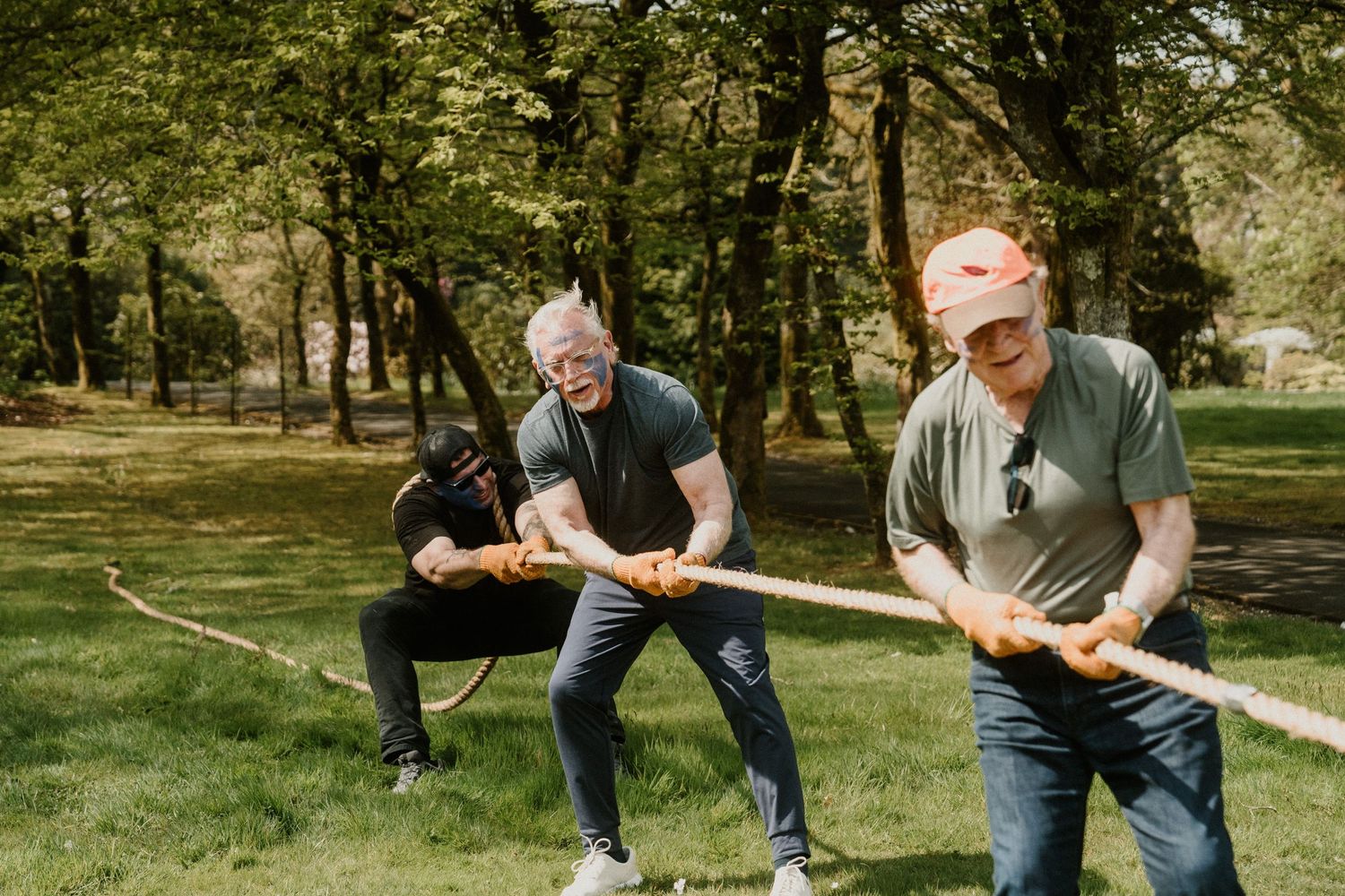 Two people practice axe throwing stances in a sunny outdoor setting.
