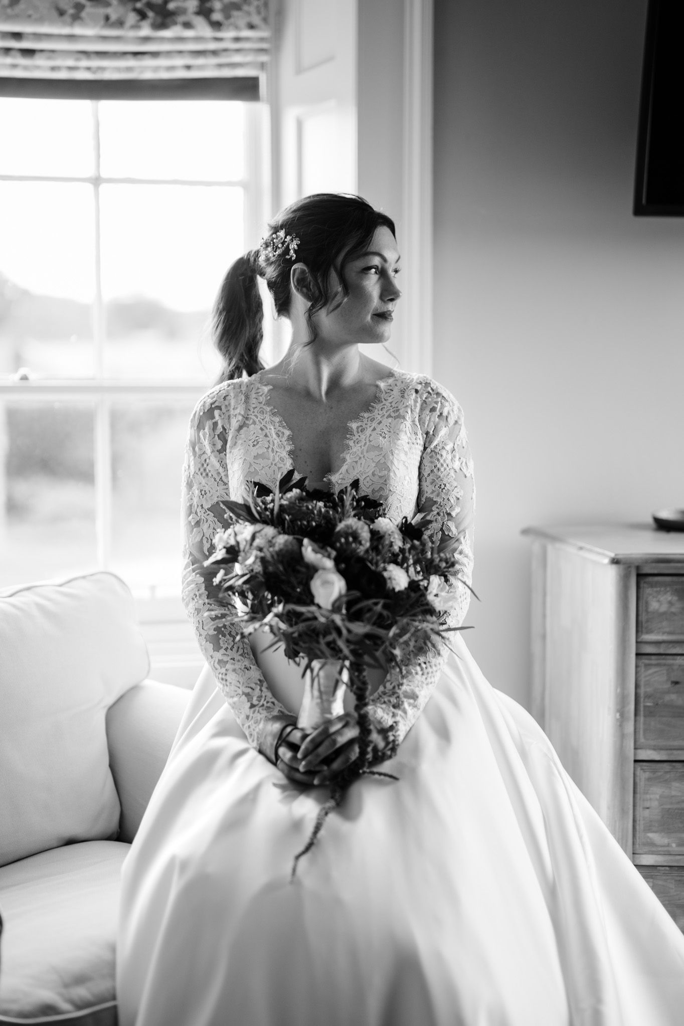 Artistic black and white series of a wedding dress and bouquet in natural window light.