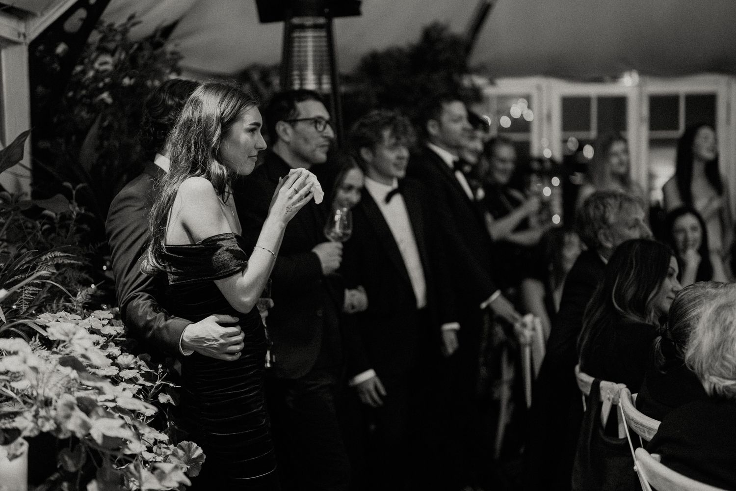 Candlelit wedding reception venue with guests mingling in formal attire.