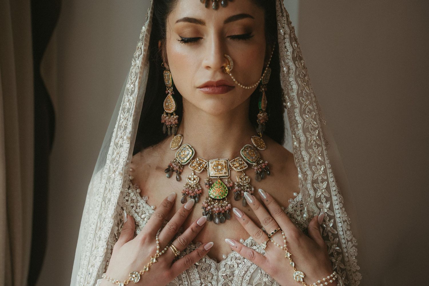 Close-up details of ornate South Asian bridal jewelry and traditional wedding makeup.