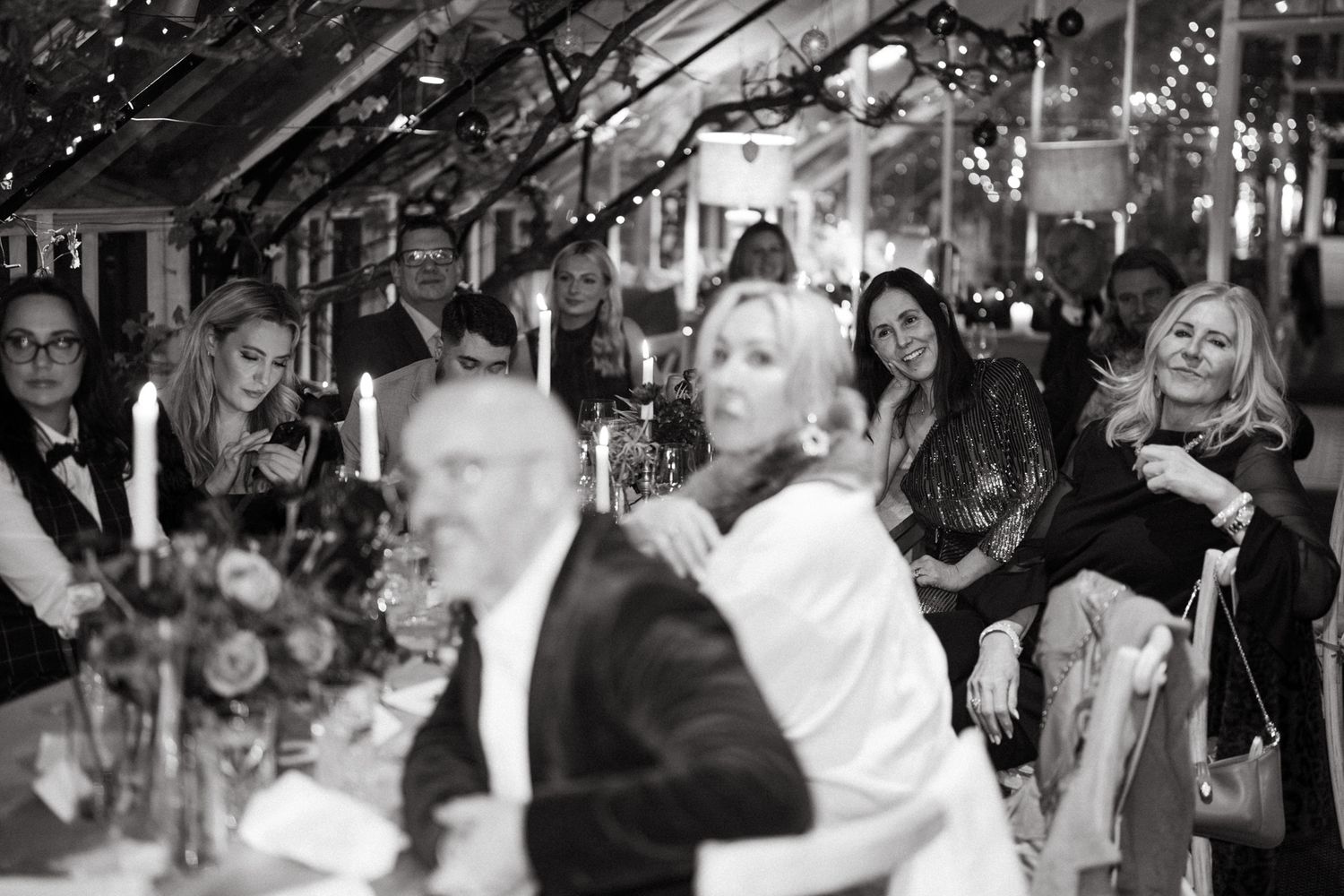 Guests mingle and celebrate at an elegant indoor wedding reception with warm lighting and festive atmosphere.
