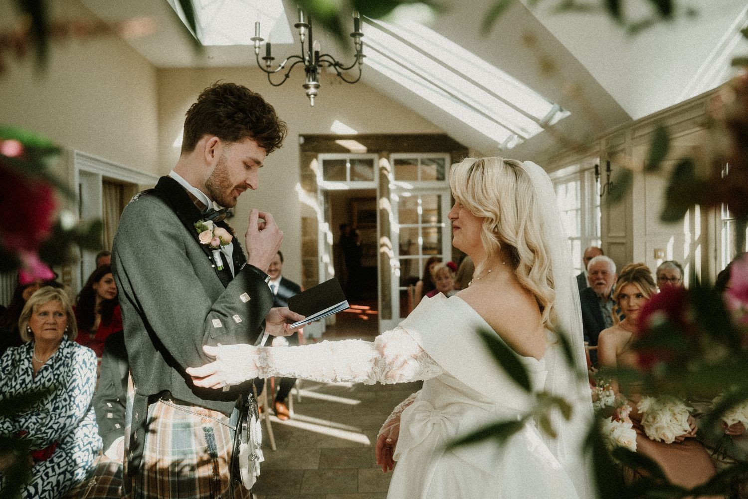 Indoor wedding ceremony venue with decorative floral arrangements and natural lighting.