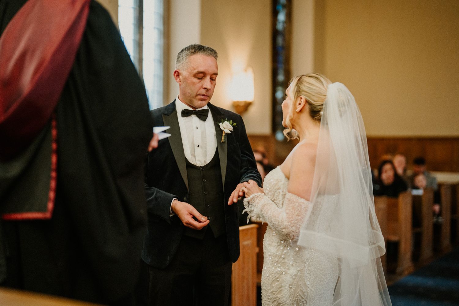 A couple exchanges vows during their wedding ceremony in a traditional church setting.