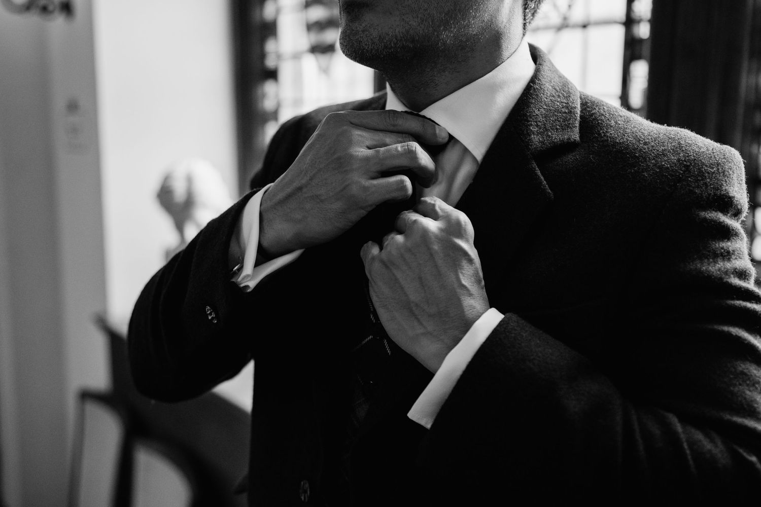 Men in formal suits getting ready for a wedding ceremony.