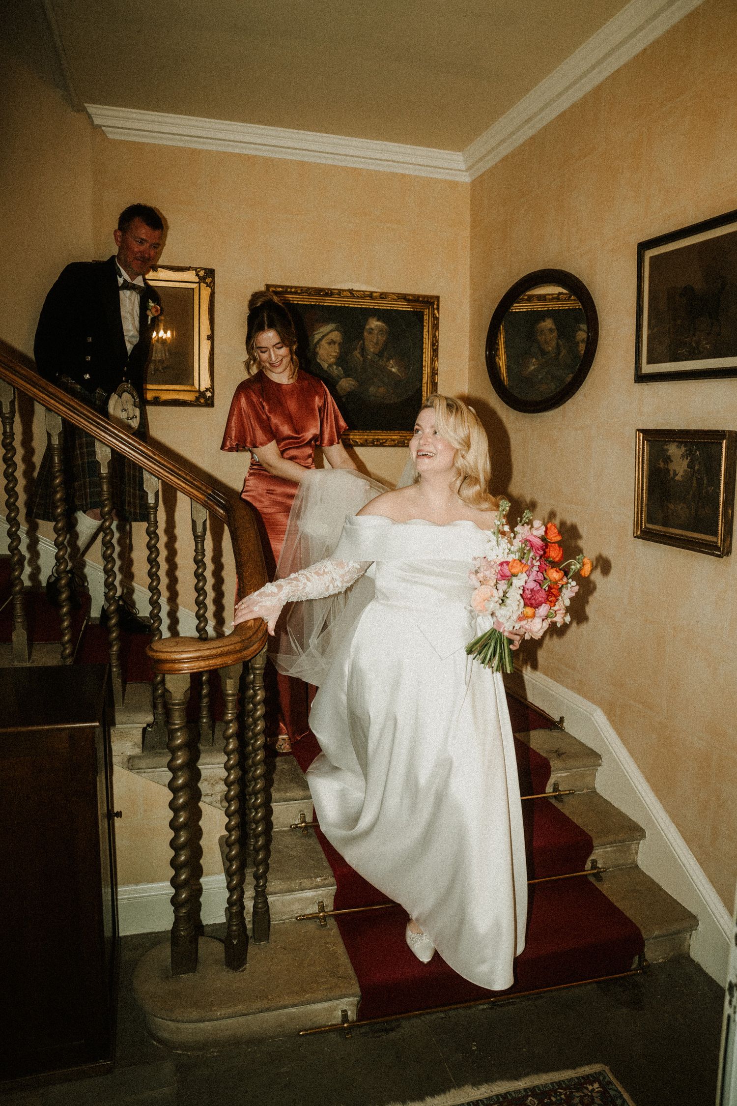 Wedding party descending ornate wooden staircase in vintage-style sequence shots.