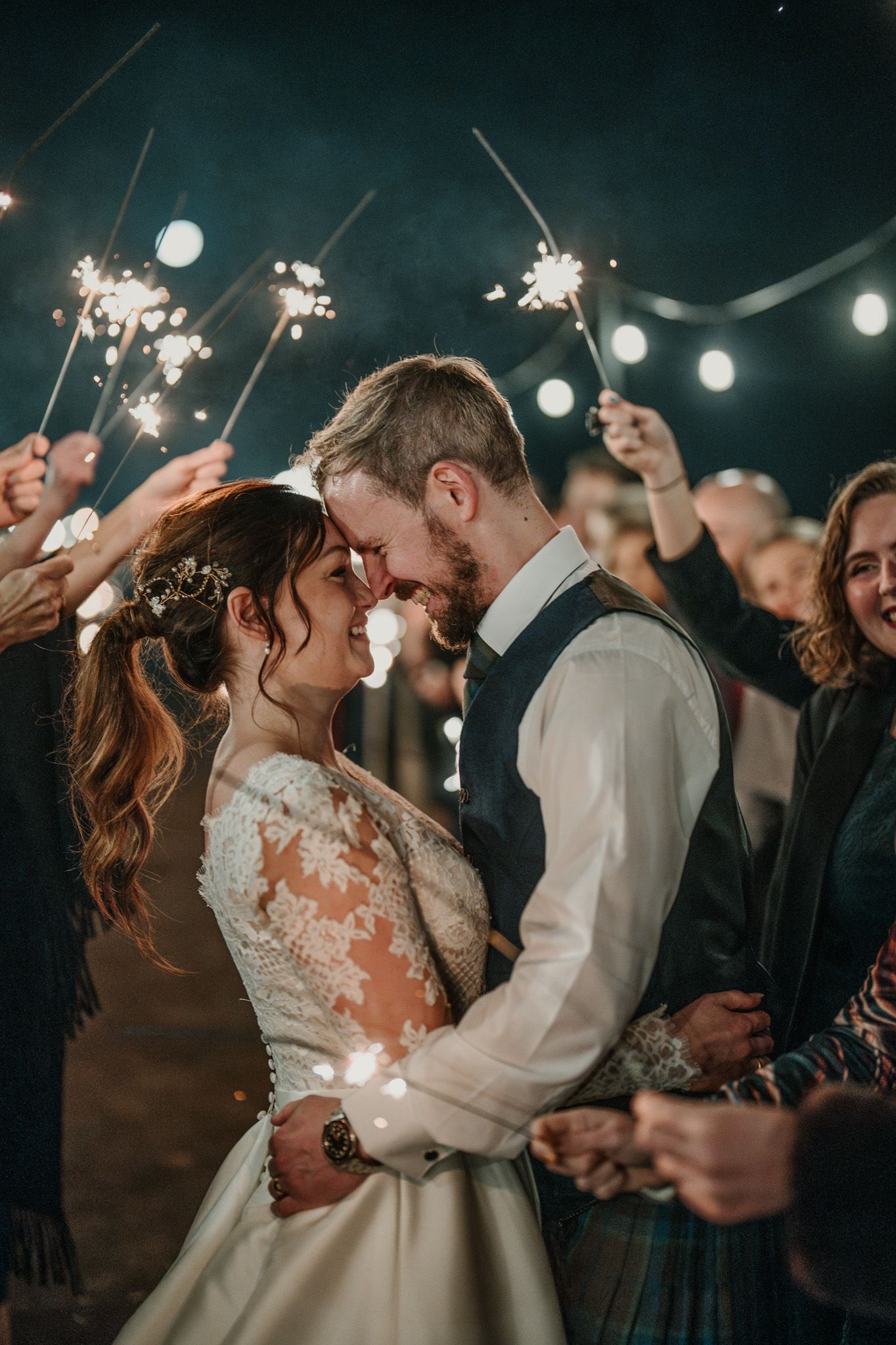 A romantic sparkler-lit moment during an evening wedding celebration.