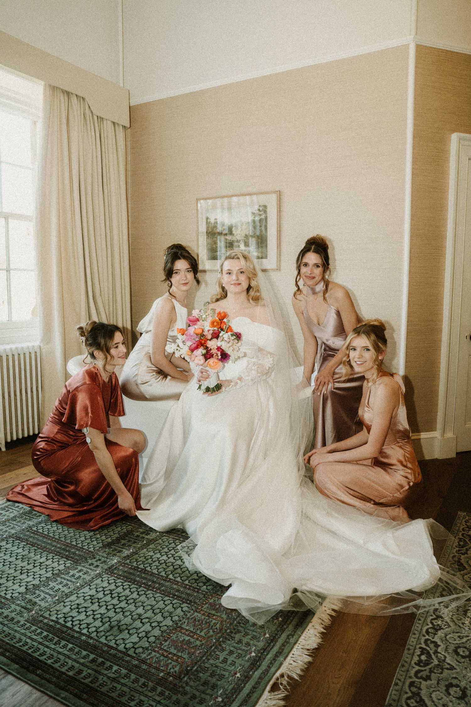 Wedding party relaxes on a vintage rug during pre-ceremony preparations.