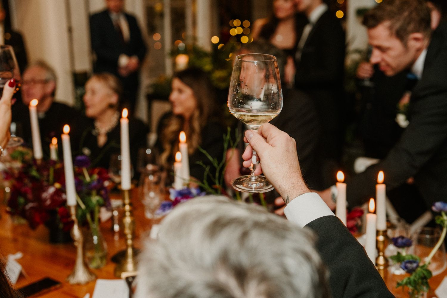 Candlelit wedding reception tables with guests enjoying the evening celebration.