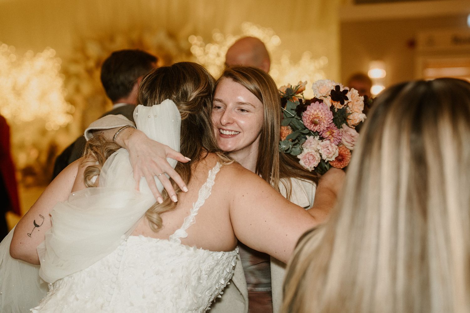 Wedding party celebrating with champagne toasts in an elegant indoor venue.