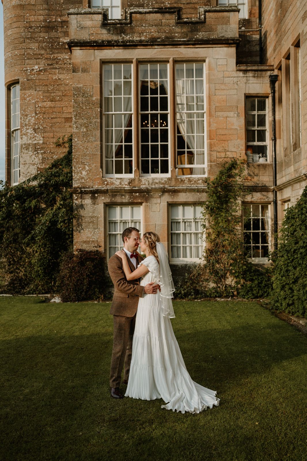 Wedding portraits against historic stone architecture with ivy-covered walls.