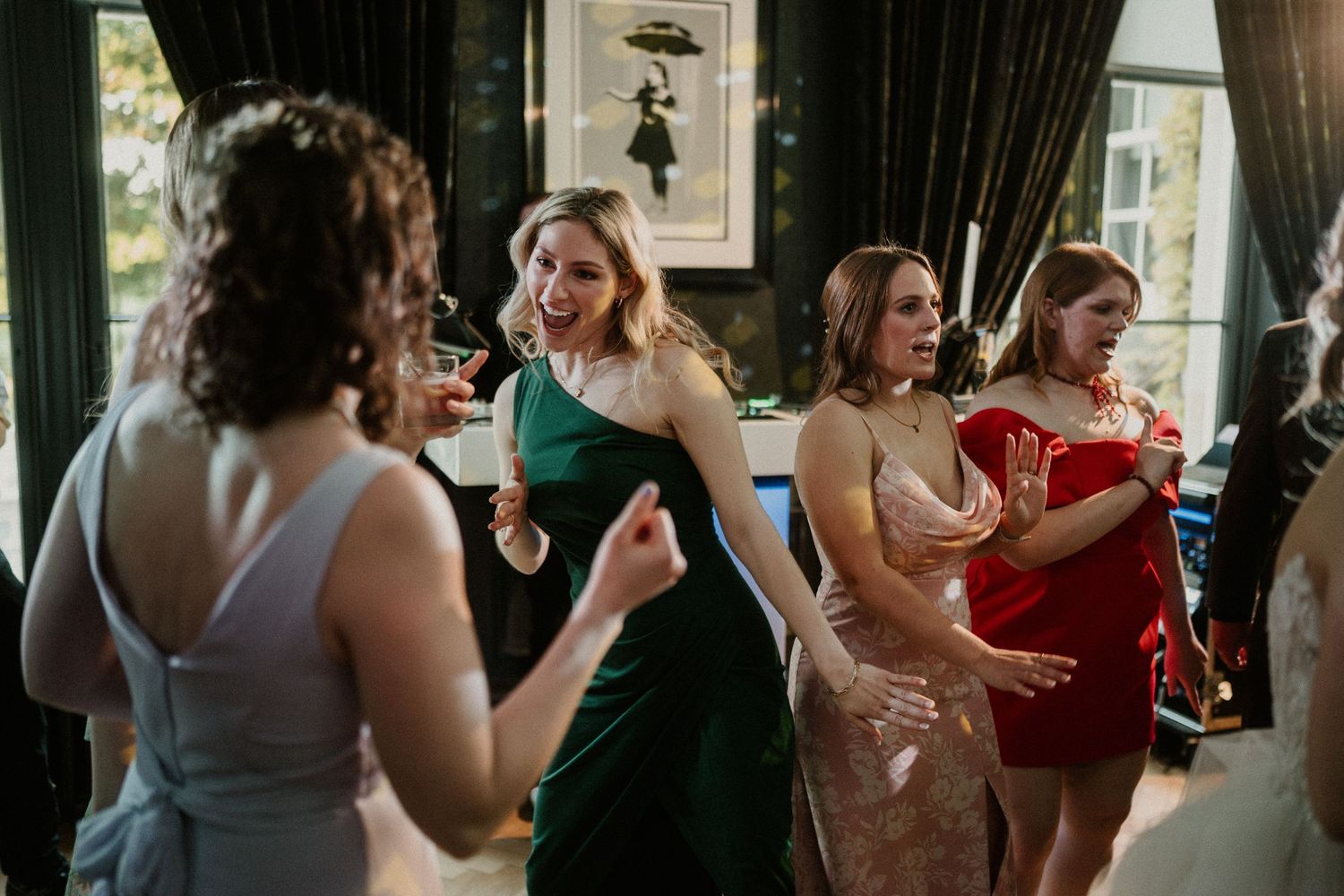 Wedding guests dancing and socializing at an elegant indoor venue.