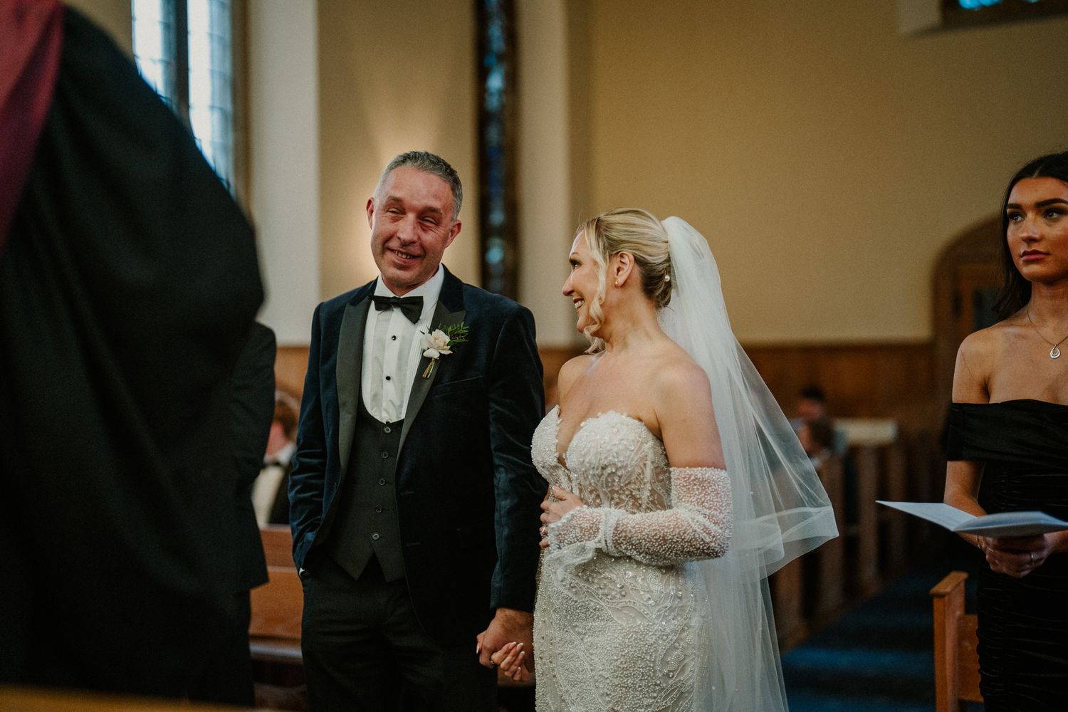 Traditional church wedding ceremony with attendees gathered in wooden pews.