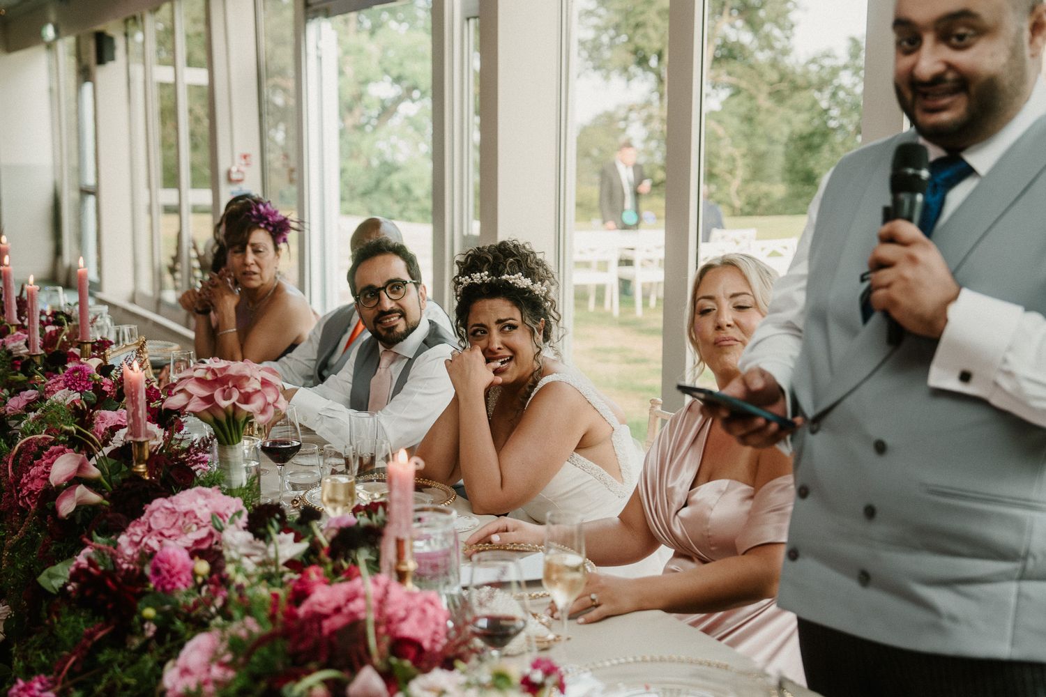 Joyful wedding reception celebration with guests seated at decorated tables.
