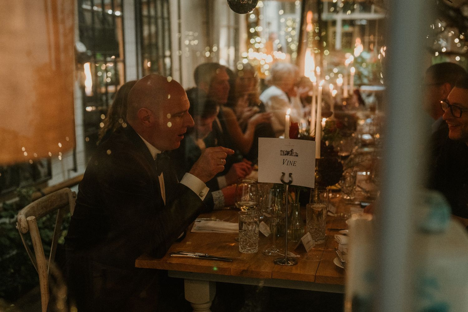 Dimly lit reception venue with elegant table settings and ambient lighting.