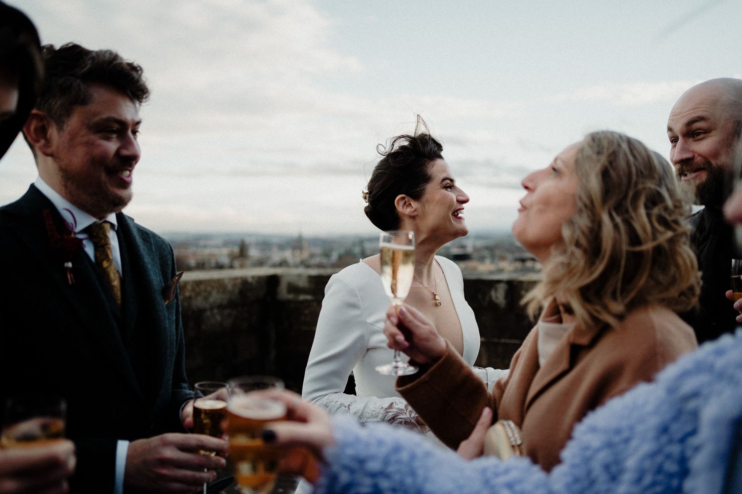 Wedding guests share joyful moments and laughter during an outdoor celebration.