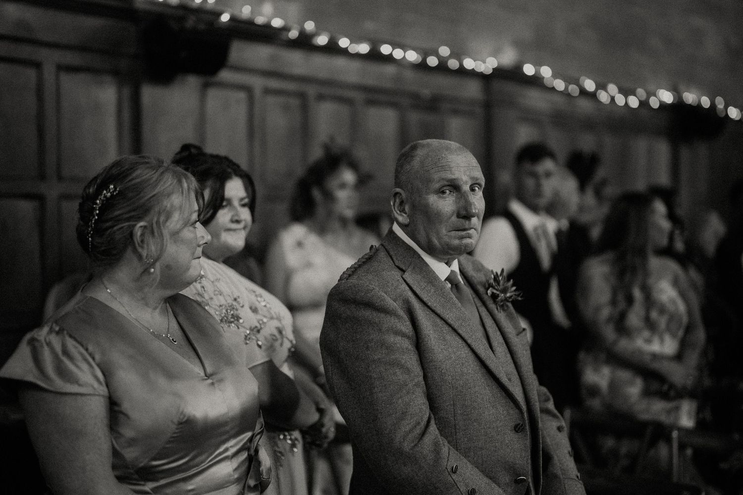 Black and white vintage wedding photograph showing guests watching the ceremony.