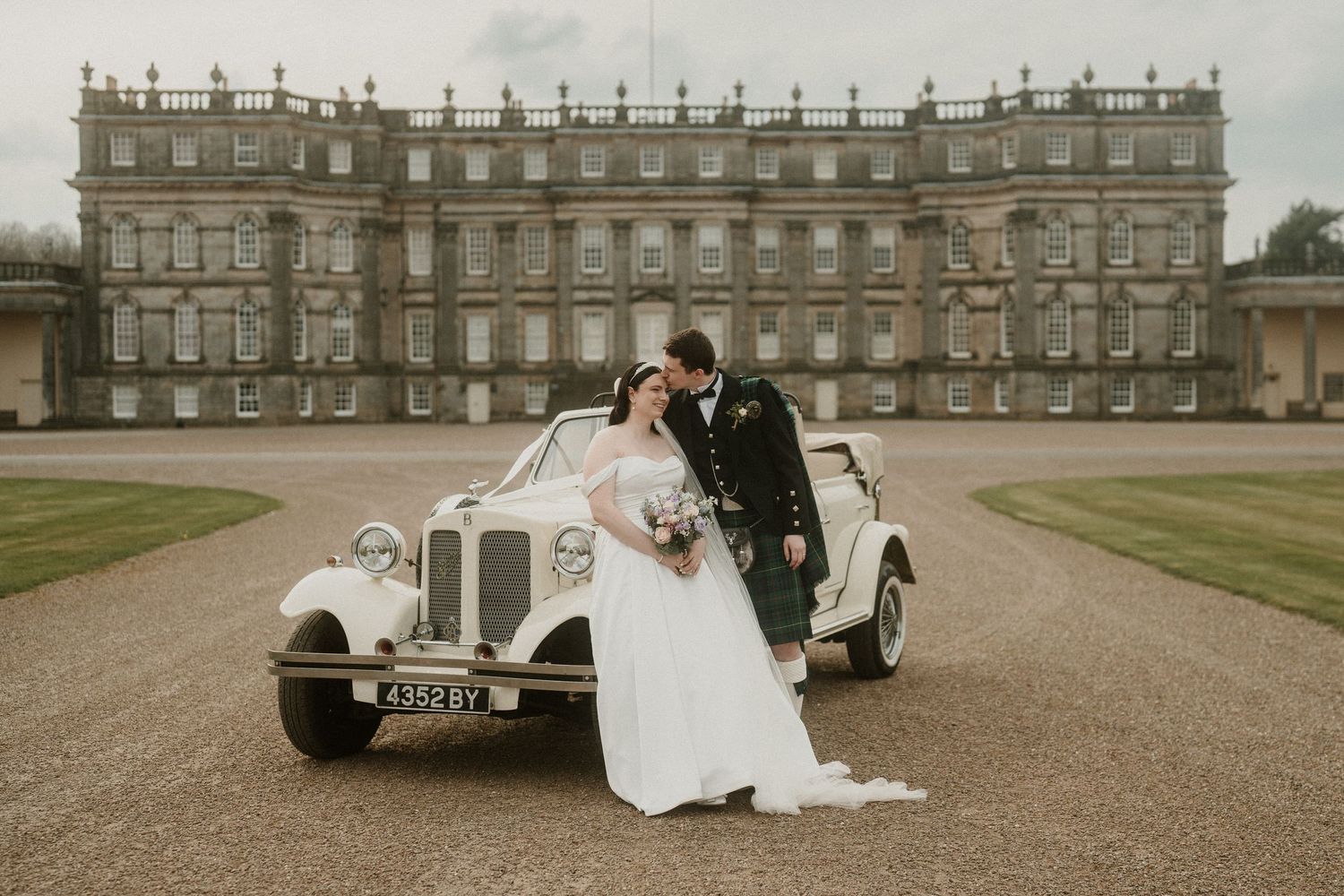 Classic wedding car parked in front of majestic Scottish manor house. Hopetoun House, Scotland.