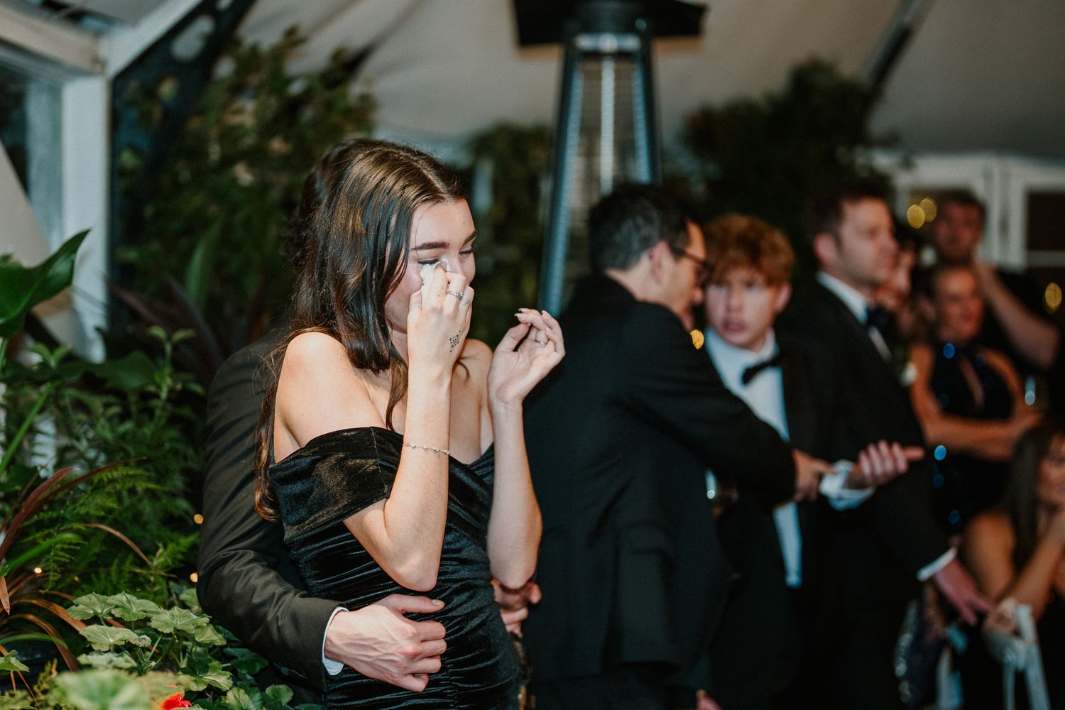 Wedding guests socialize during an evening reception in a beautifully decorated indoor venue.