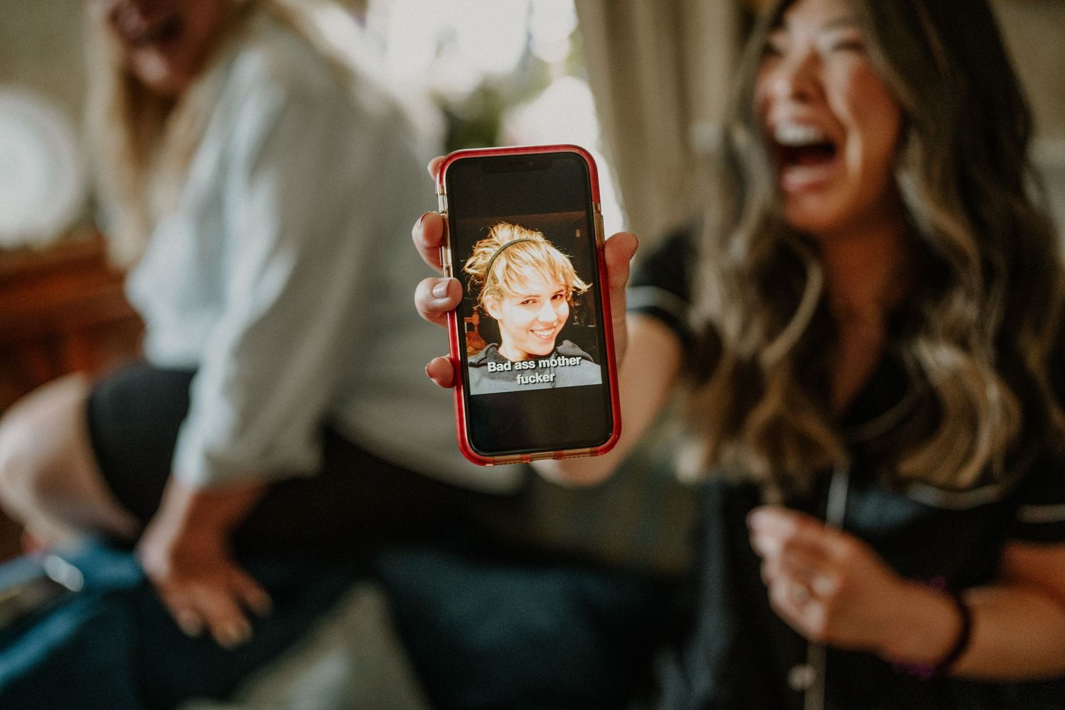 Wedding guests laughing and taking photos during celebration.