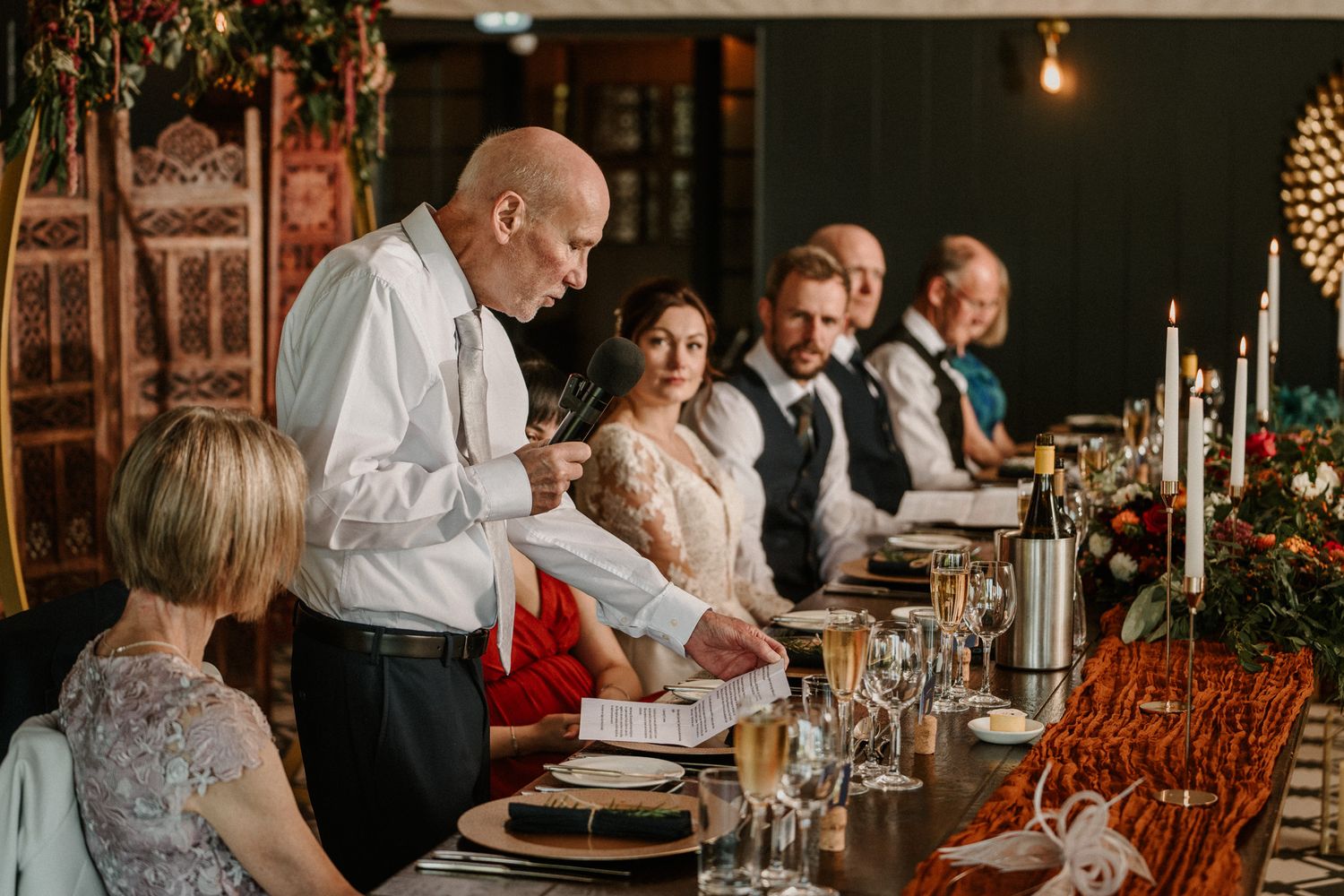 Wedding reception dinner in a rustic venue with ambient lighting and wooden decor.