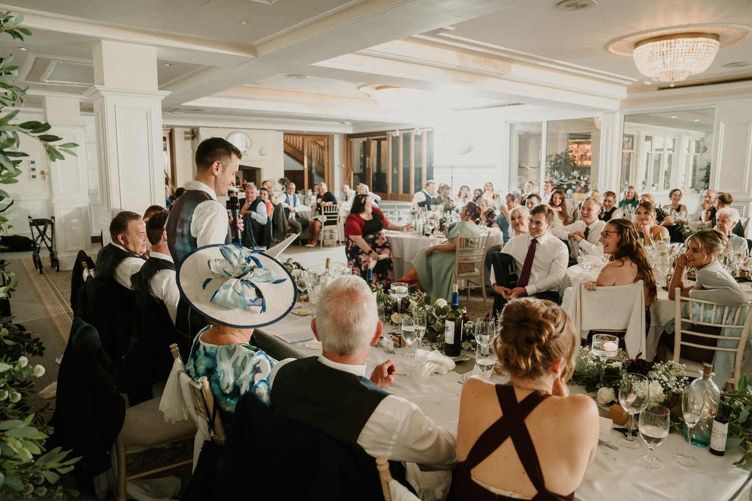 Elegant wedding reception venue decorated with floral centerpieces and crystal chandeliers.