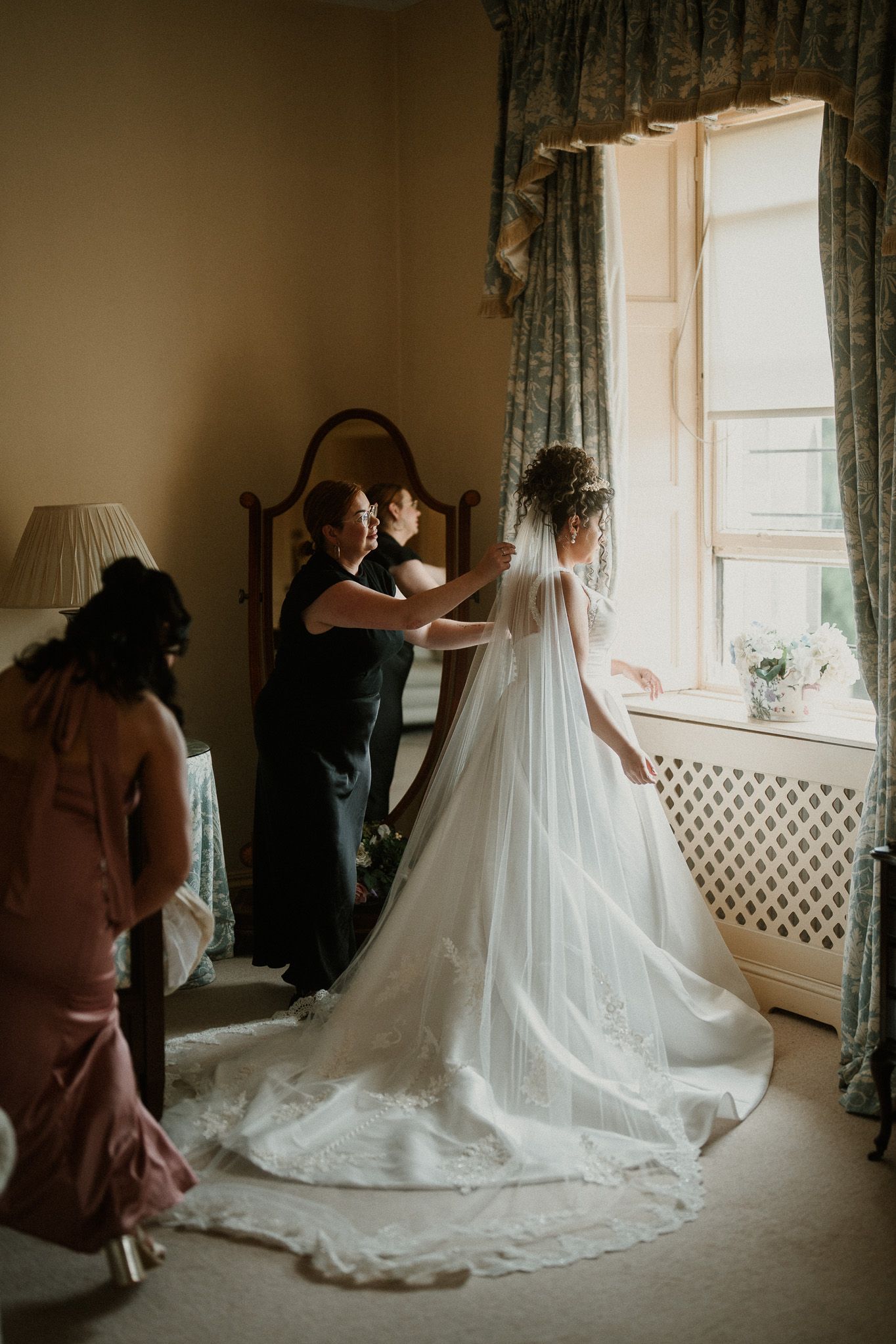 Elegant white wedding dress with long train photographed in sequence by window light.