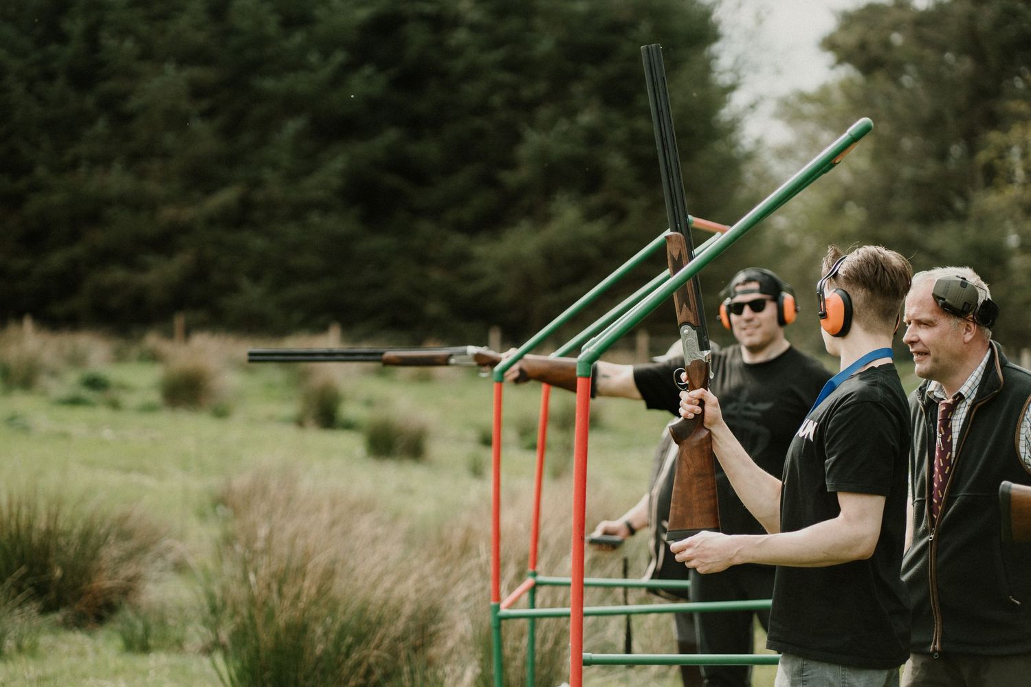 People participating in outdoor archery lessons on a sunny day.