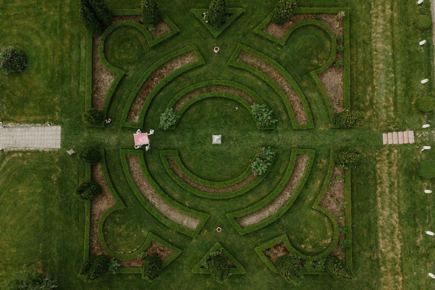 Aerial view of elaborate formal garden with circular hedge patterns and pathways.