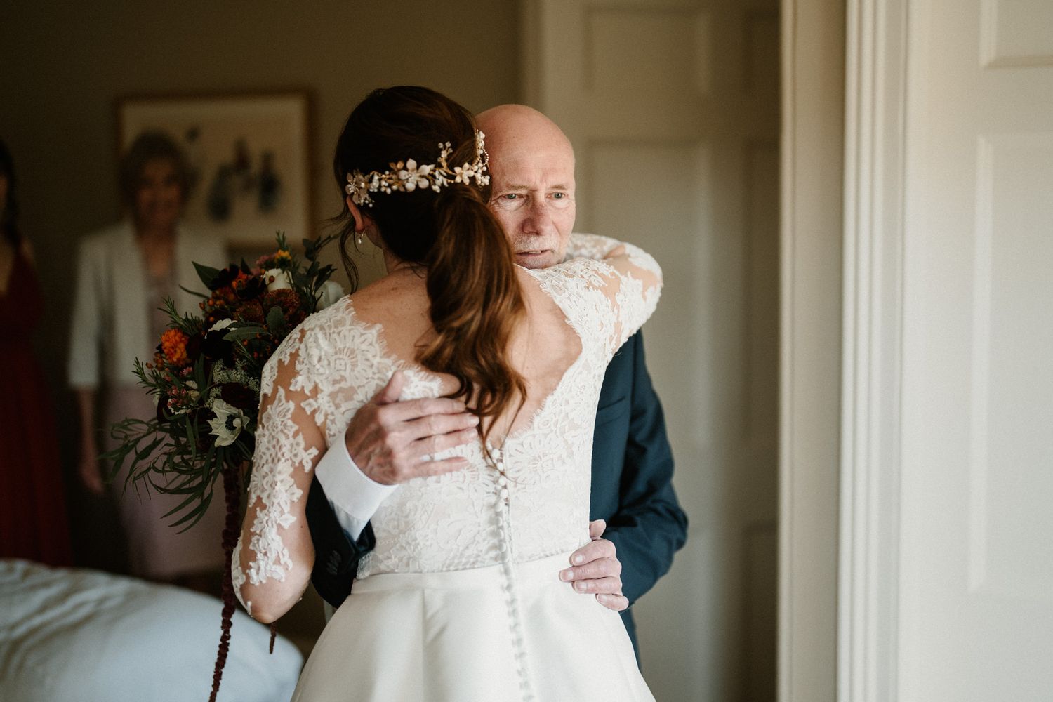 Intimate wedding moments captured between family members in a softly lit indoor setting.