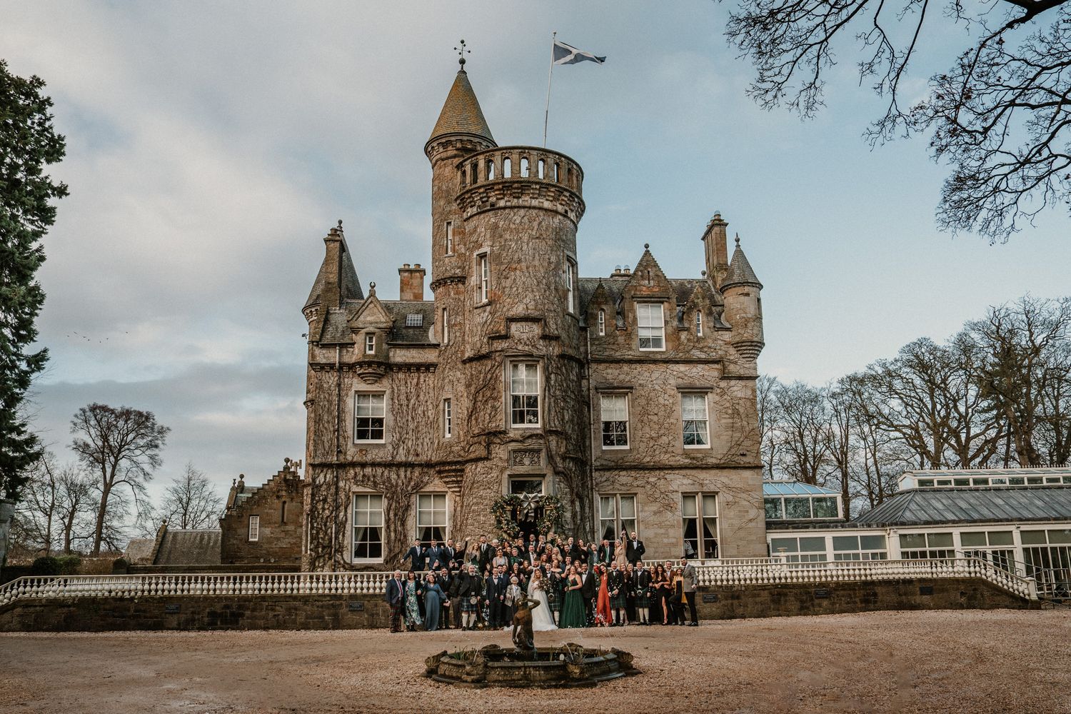 Majestic Scottish castle venue with wedding party gathered at entrance.