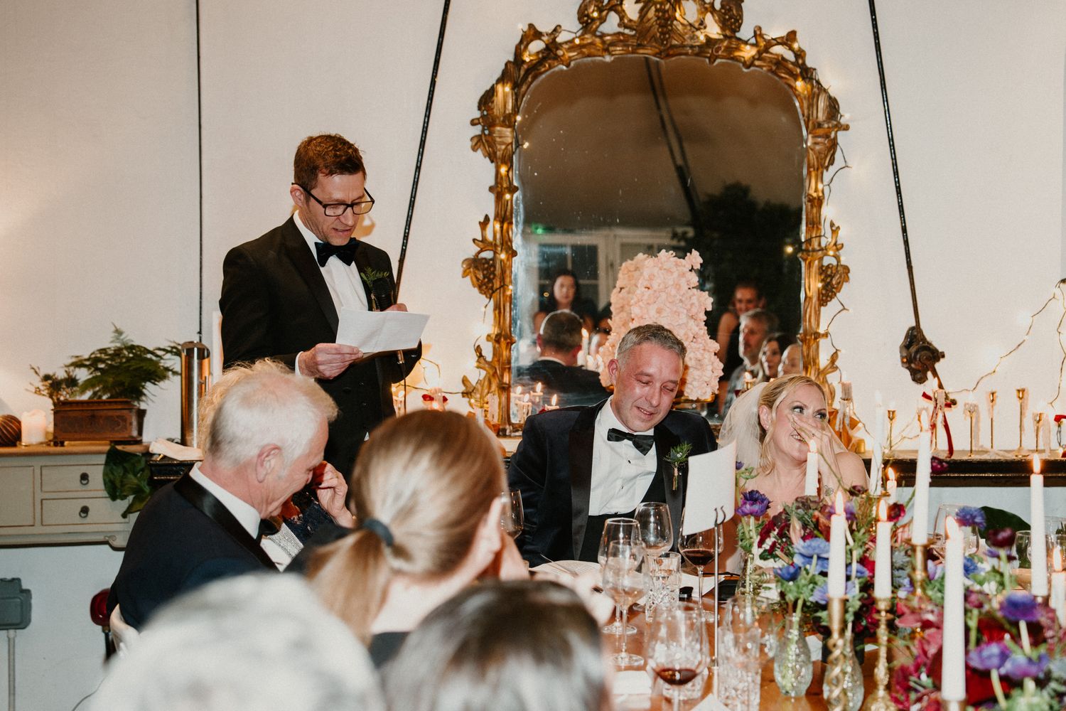 Formal wedding reception with gilded mirrors and crystal chandeliers decorating the elegant space.