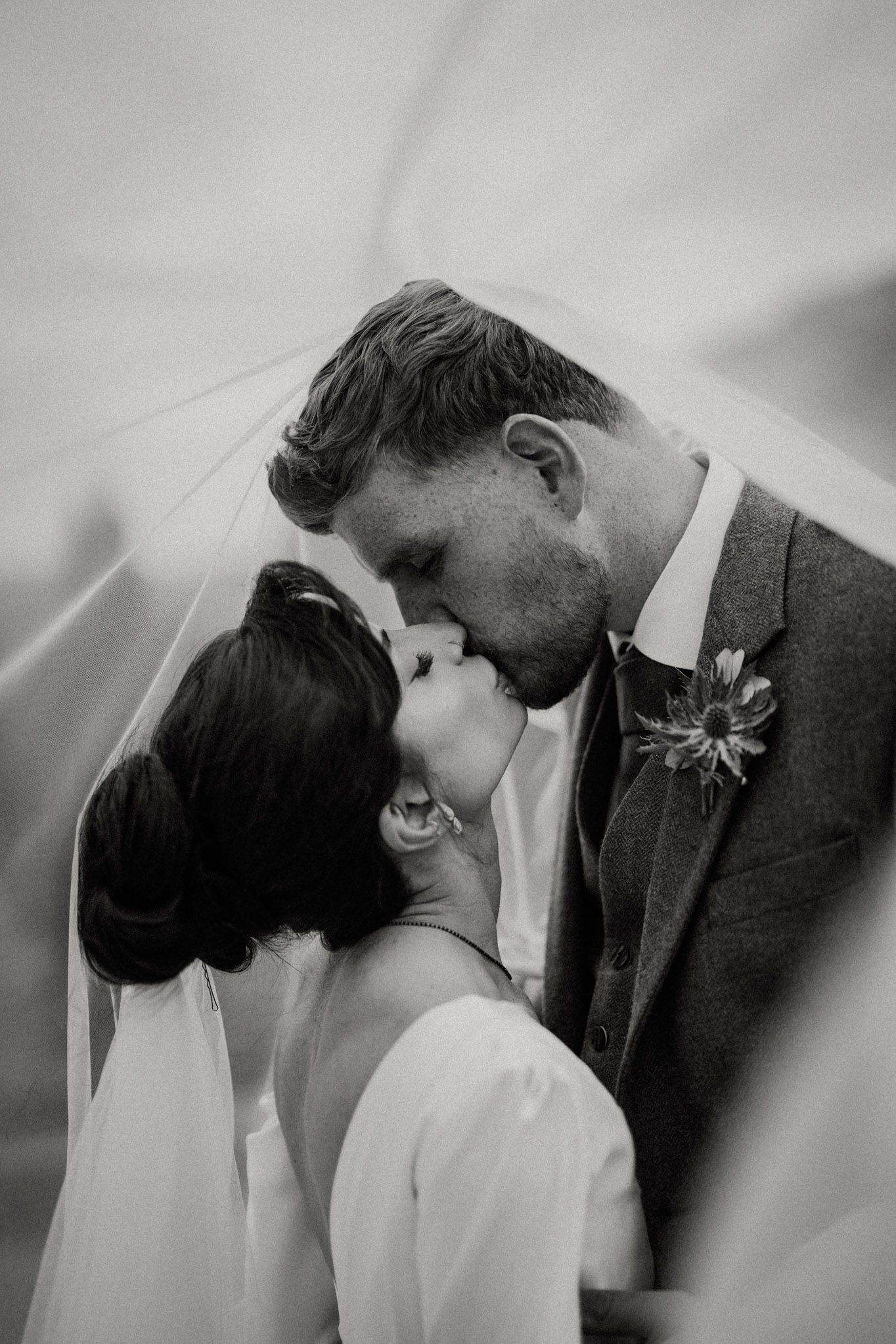 A romantic black and white photo series showing a couple in wedding attire sharing intimate kisses.