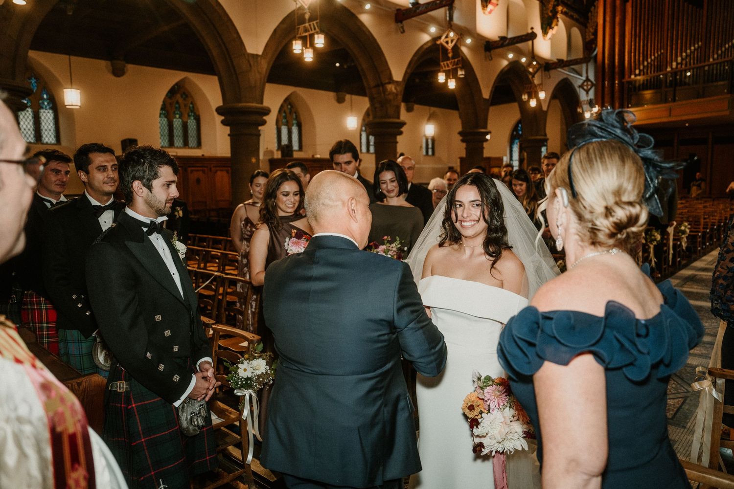 Elegant wedding celebration inside historic church with gothic arches and warm lighting.