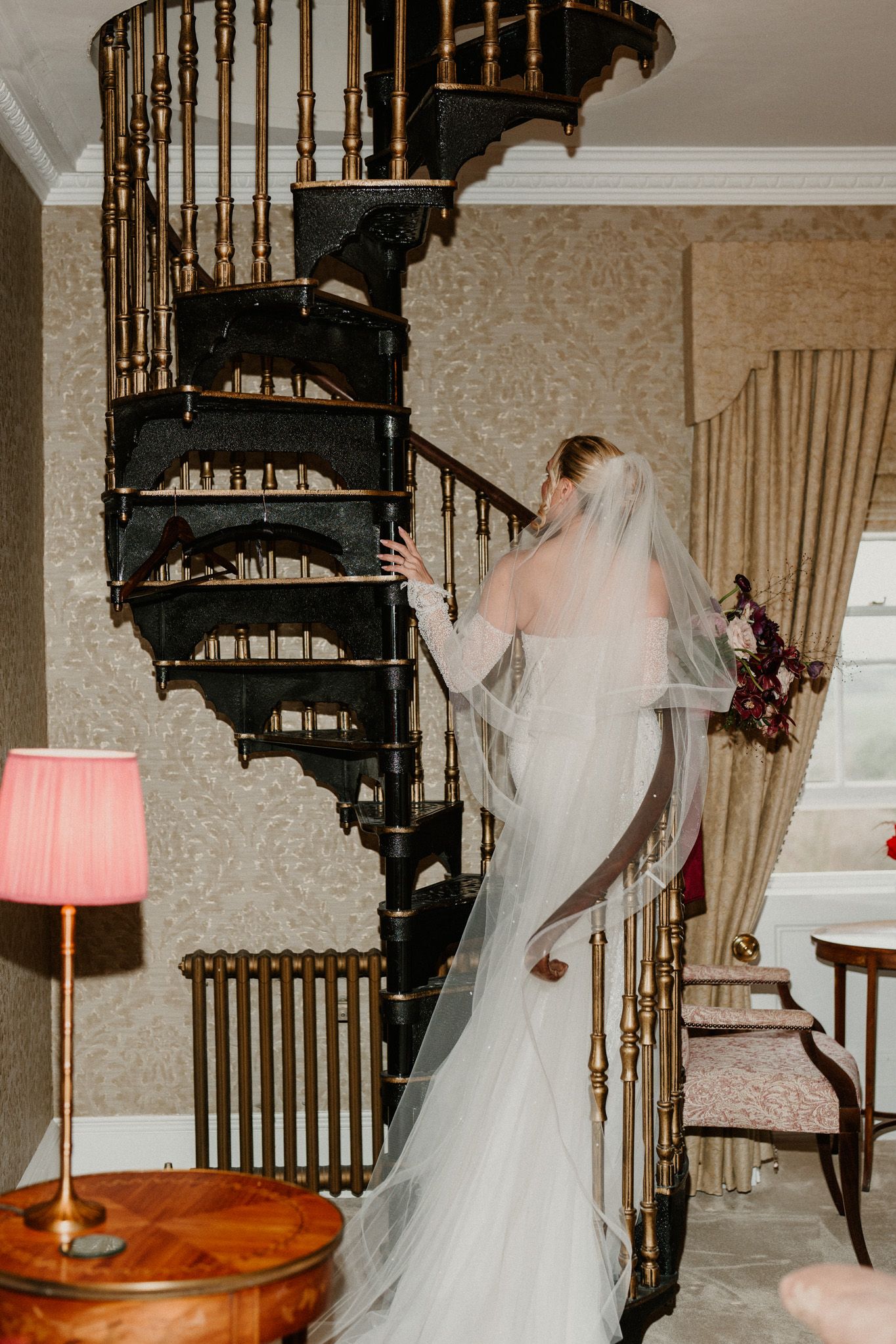 Vintage-style room featuring a wrought iron spiral staircase and bridal preparations.