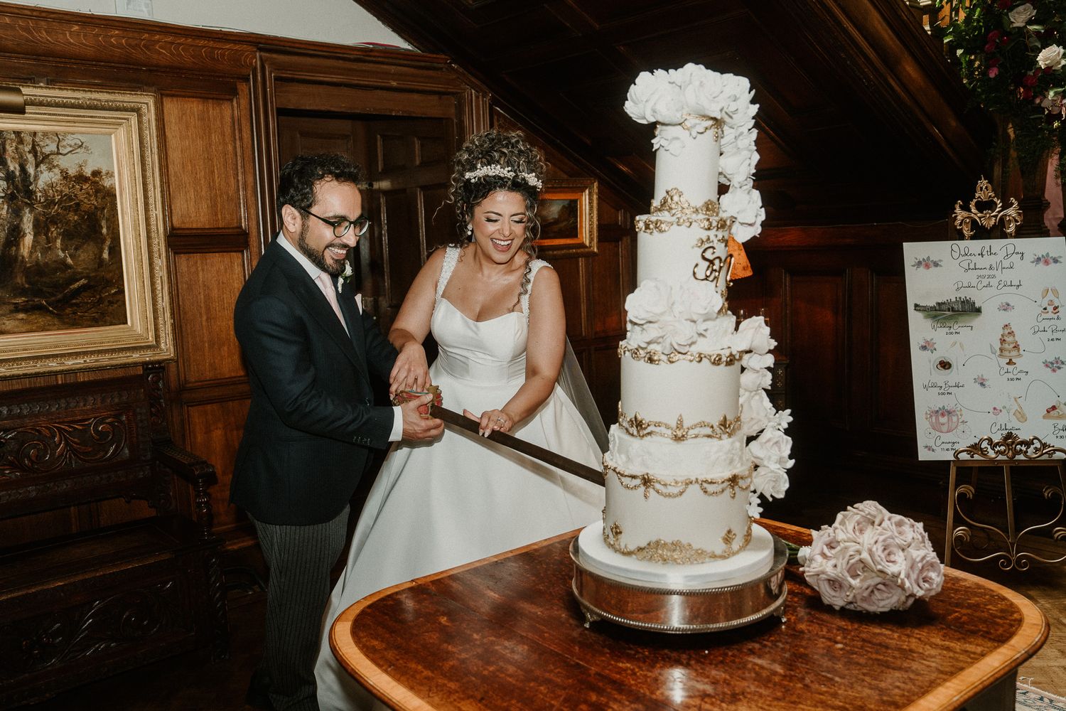 Elegant wedding cake cutting moment at a formal reception with ornate tiered cake.