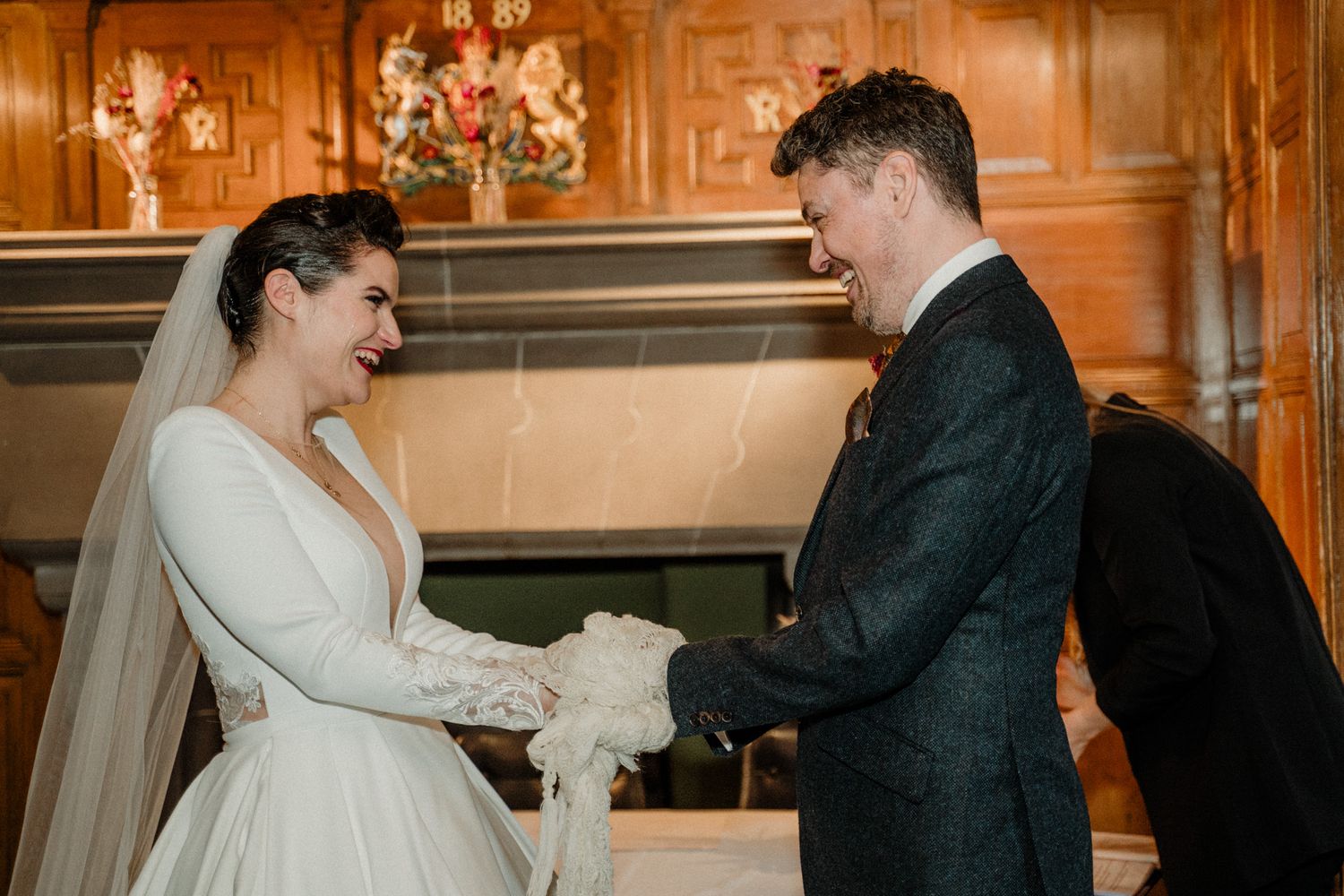Elegant wedding ceremony in a richly decorated wooden interior room.